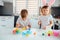 Brother and sister painting Easter eggs. Children make holiday decorations while sitting at the kitchen table.