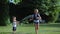 Brother and sister at park, wet children fooling around watering each other from a garden hose on hot summer day