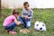 Brother and sister playing on ground and eats sweets candy from pinata toy. Boy and girl on meadow in garden playing