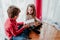 brother and sister playing and having fun at home by the christmas tree. Family time. Christmas concept