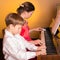 Brother And Sister Playing Piano. Piano player.