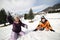 Brother and sister playing in the snow in winter