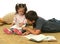 Brother and sister reading books on the floor