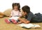 Brother and sister reading books on the floor