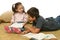 Brother and sister reading books on the floor