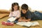 Brother and sister reading books on the floor