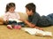 Brother and sister reading books on the floor