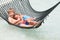 Brother And Sister Relaxing In Beach Hammock