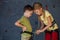 Brother and sister standing near a rock wall for climbing indoor