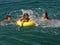 Brother and sisters with beach toys on sea