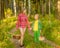 Brother and sisters picking mushrooms in the forest