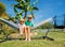 Brothers boys sit in the hammock at backyard garden