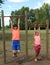 Brothers hanging on a pole make training in an outdoor gym