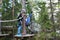 Brothers overcoming obstacle in forest adventure park