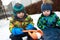 Brothers playing with snowball maker
