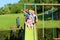 Brothers and sister playing on slide in the garden