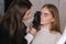 Brow master applies henna on eyebrows for beautiful blond hair woman