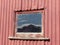 Brow Peak mountain reflected in barn window