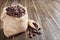 Brown aromatic roasted coffee beans with smoke in a bag on a wooden background