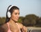 Brown and attractive Venezuelan woman, goes running with big headphones to listen music