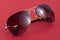 Brown aviator sunglasses on red