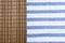 Brown bamboo mat on table cloth with blue stripe.