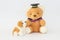 A brown bear wearing a graduation cap and a brownish white dog doll.