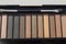 Brown and beige eyeshadow in black palette case, Nude powder shades with makeup brush, top beauty