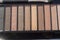 Brown and beige eyeshadow in black palette case, Nude powder shades with makeup brush, top beauty