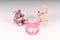 Brown and beige teddy bears toys near pink bodysuit for newborn and socks