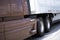 Brown big rig semi truck with white trailer for professional lon
