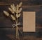 Brown blank paper card on wooden table with dried flowers