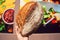 Brown bread in hand of customer near city supermarket wall