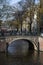 Brown bridge with bikes over the canal in autumn in Amsterdam