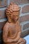 Brown Buddha with a stone bricks wall background