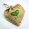 A brown burlap bag in the shape of a green heart