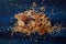 Brown cane sugar on a blue wooden board, spilled large crystals of brown sugar around