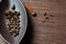 Brown canoe-shaped dish on bamboo mat with coffee beans, star anise, cloves and cinnamon