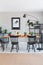 Brown carpet in front of black chairs and wooden table with food in grey dining room interior