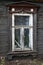 Brown carved platband cracked glass window of old traditional russian wooden house