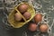 Brown chicken eggs in a basket and on the hay, green table, gray background. Easter preparations