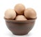 Brown chicken organic eggs in clay bowl  on white background