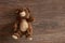 Brown children`s teddy bear lies on the wooden floor