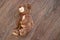 Brown children`s teddy bear lies on the wooden floor