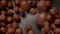 Brown choco cereal balls falling into a bowl, close up