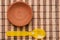 Brown clay disk with yellow plastic spoon