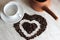 brown clay Turk for cooking Arabic coffee, white clean Cup and saucer and roasted coffee beans in the shape of a heart on the