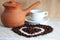 Brown clay Turk for cooking Arabic coffee, white Cup and saucer and roasted coffee beans in the shape of a heart