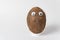 Brown coconut with Googly eyes on white background. Nut character with funny face