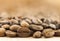 Brown coffee beans with white smoke vapour on yellow textured wooden board background close up.